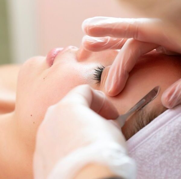 Rosto de uma mulher com semblante tranquilo, recebendo tratamento Dermaplaning​ em duque de caxias, por profissional de estética facial