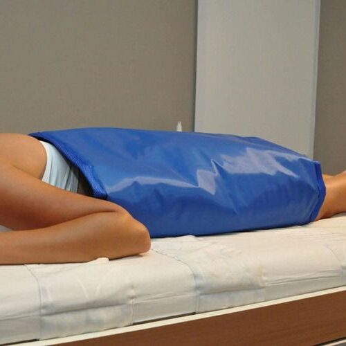 Mulher deitada de bruços com manta azul encima realizando Detox corporal em Bairro 25 de agosto